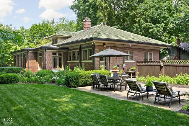 4455 Broadway St, Indianapolis, IN 46205 - back of property featuring brick siding, a patio area, and a chimney