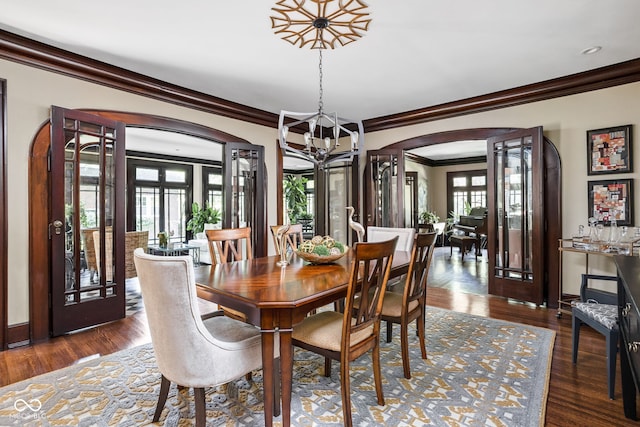 4455 Broadway St, Indianapolis, IN 46205 - dining space featuring crown molding, arched walkways, a chandelier, french doors, and wood finished floors