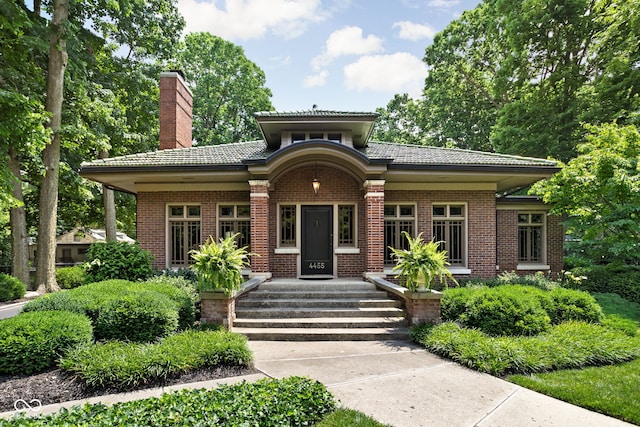 4455 Broadway St, Indianapolis, IN 46205 - view of front of home featuring a chimney, brick siding, and a tile roof