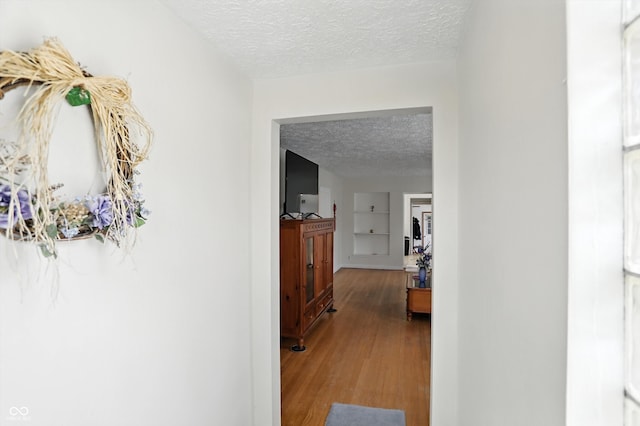 95 S 11th Ave, Beech Grove, IN 46107 - corridor featuring a textured ceiling, wood finished floors, and built in shelves