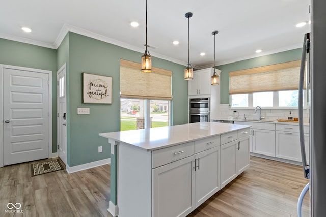 19959 Cowie Ln, Westfield, IN 46074 - kitchen featuring appliances with stainless steel finishes, ornamental molding, white cabinets, light wood finished floors, and recessed lighting