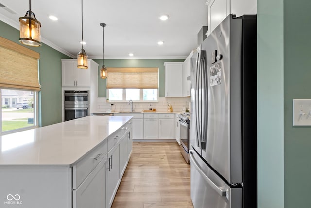 19959 Cowie Ln, Westfield, IN 46074 - kitchen with appliances with stainless steel finishes, light countertops, light wood finished floors, backsplash, and white cabinetry