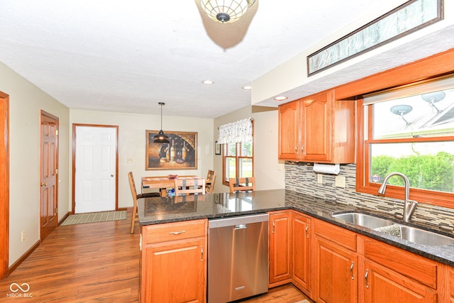 662 Leah Way, Greenwood, IN 46142 - kitchen featuring stainless steel dishwasher, a peninsula, light wood-style floors, tasteful backsplash, and dark stone counters