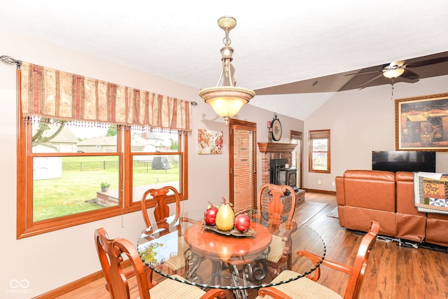 662 Leah Way, Greenwood, IN 46142 - dining area featuring light wood-style flooring, a brick fireplace, ceiling fan, and vaulted ceiling