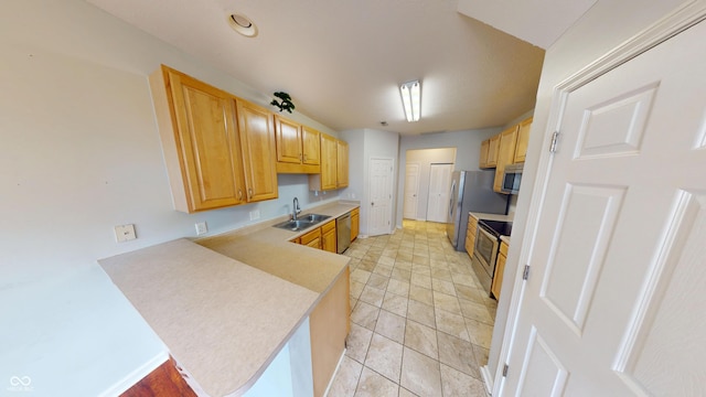 2259 Colfax Ln Unit 2259, Indianapolis, IN 46260 - kitchen featuring appliances with stainless steel finishes, light countertops, a peninsula, light tile patterned floors, and light brown cabinets