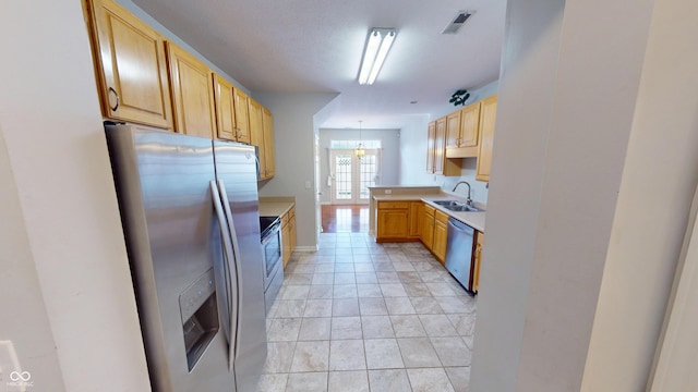 2259 Colfax Ln Unit 2259, Indianapolis, IN 46260 - kitchen with appliances with stainless steel finishes, light countertops, a chandelier, decorative light fixtures, and light brown cabinetry