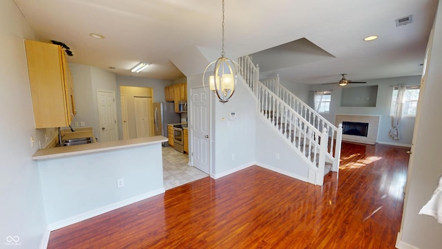 2259 Colfax Ln Unit 2259, Indianapolis, IN 46260 - unfurnished dining area with light wood-style flooring, stairway, a ceiling fan, a glass covered fireplace, and recessed lighting