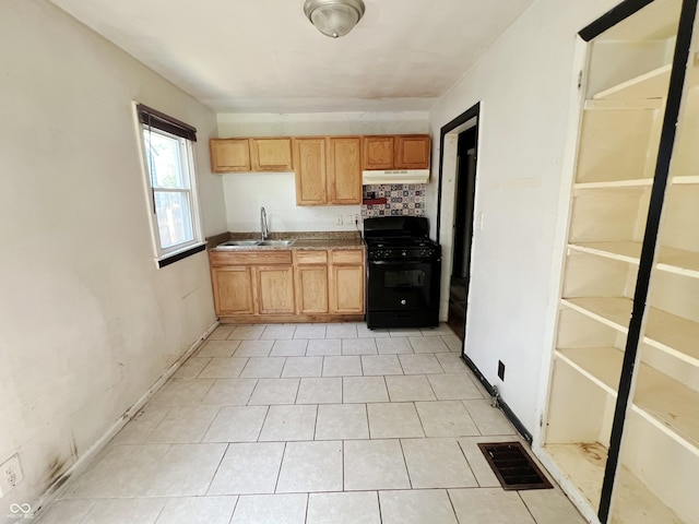 1601 E 44th St, Indianapolis, IN 46205 - kitchen with black gas range oven, under cabinet range hood, dark countertops, and light tile patterned floors