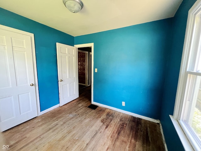 1601 E 44th St, Indianapolis, IN 46205 - unfurnished bedroom featuring wood finished floors and multiple windows