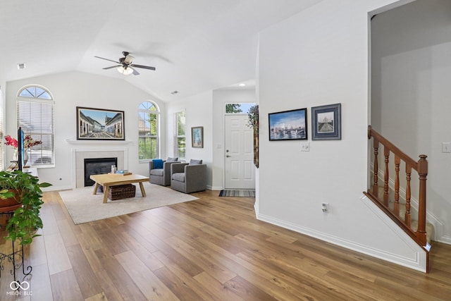 16636 Brownstone Ct, Westfield, IN 46074 - living area featuring light wood-type flooring, ceiling fan, a glass covered fireplace, lofted ceiling, and stairs