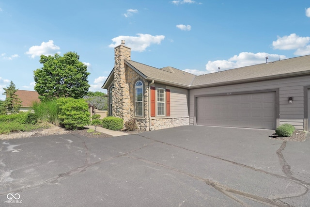 16636 Brownstone Ct, Westfield, IN 46074 - view of front facade featuring stone siding, driveway, a chimney, and a garage