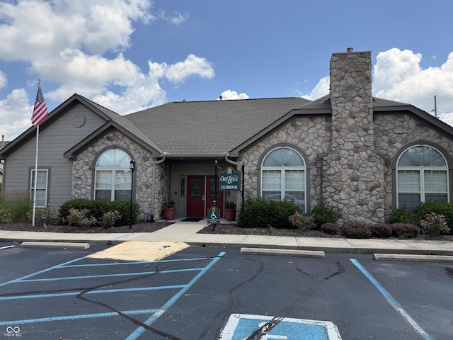 16636 Brownstone Ct, Westfield, IN 46074 - view of front of property with stone siding, uncovered parking, a shingled roof, and a chimney