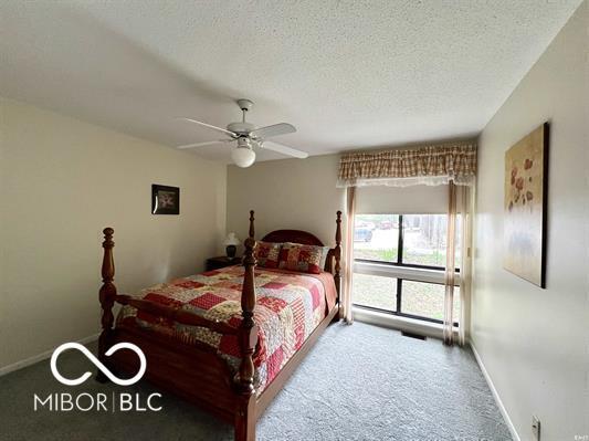 9369 S Pointe Lasalles Dr, Bloomington, IN 47401 - bedroom with carpet floors, a textured ceiling, and a ceiling fan