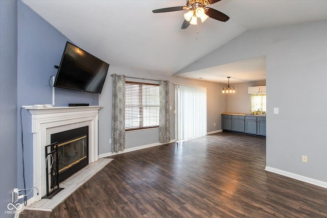 142 Hilltop Farms Blvd, Whiteland, IN 46184 - unfurnished living room featuring a tiled fireplace, lofted ceiling, ceiling fan, wood finished floors, and a chandelier
