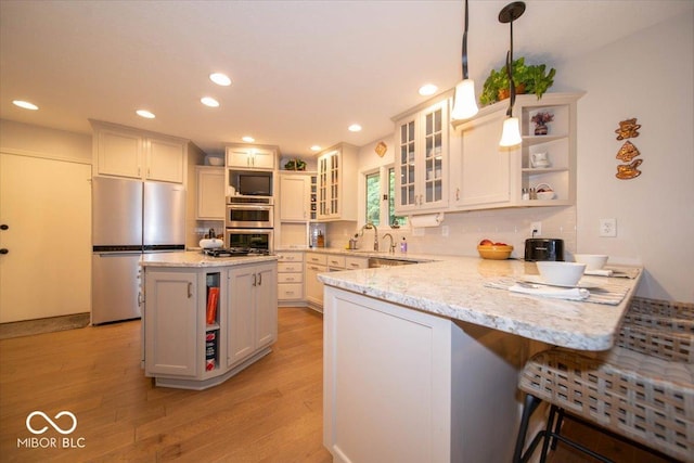 8550 Tidewater Ct, Indianapolis, IN 46236 - kitchen featuring appliances with stainless steel finishes, open shelves, a peninsula, light wood-type flooring, and recessed lighting