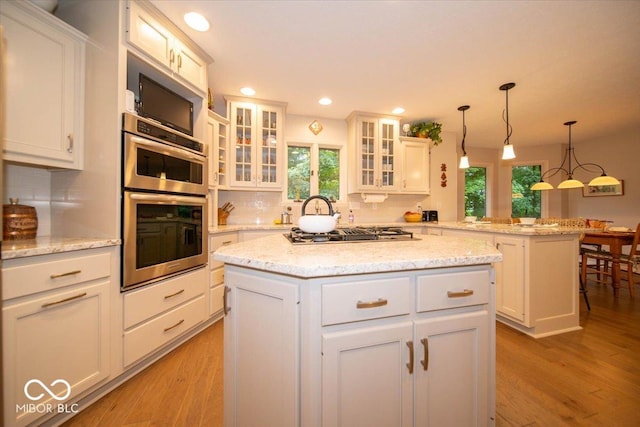 8550 Tidewater Ct, Indianapolis, IN 46236 - kitchen with stainless steel appliances, plenty of natural light, a peninsula, light wood-style floors, and recessed lighting