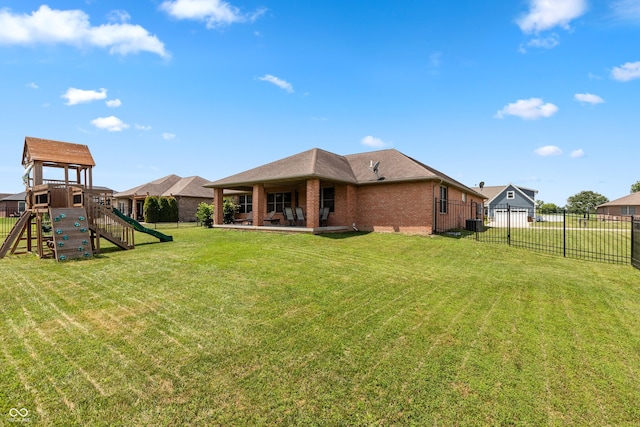 1977 Sophia Ln, Seymour, IN 47274 - back of house featuring brick siding, a playground, a fenced backyard, and a patio area