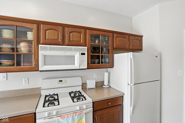 35 Decourcy Ln, Franklin, IN 46131 - kitchen with white appliances, glass insert cabinets, light countertops, and brown cabinets