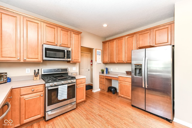 11820 Stepping Stone Dr, Fishers, IN 46037 - kitchen with appliances with stainless steel finishes, recessed lighting, light wood finished floors, light countertops, and built in study area