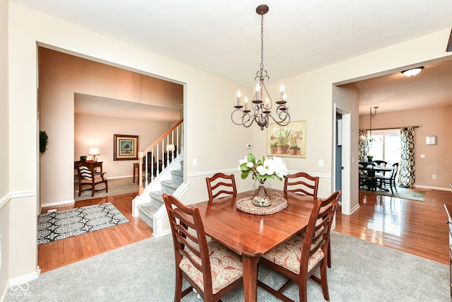 11820 Stepping Stone Dr, Fishers, IN 46037 - dining room featuring a chandelier, wood finished floors, and stairway