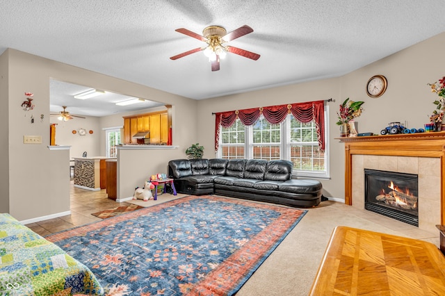 1449 Danielle Dr, Indianapolis, IN 46231 - living room featuring ceiling fan, a tiled fireplace, a textured ceiling, and tile patterned floors