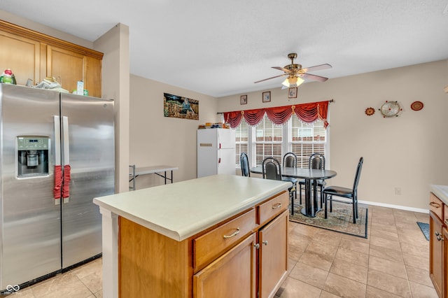 1449 Danielle Dr, Indianapolis, IN 46231 - kitchen with stainless steel fridge, ceiling fan, a center island, light tile patterned floors, and light countertops