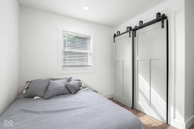 339 Honey Locust Pl, North Vernon, IN 47265 - bedroom featuring a barn door, light wood-style flooring, and recessed lighting