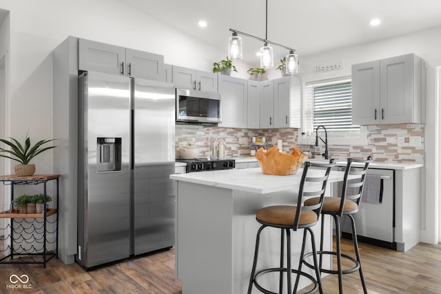 339 Honey Locust Pl, North Vernon, IN 47265 - kitchen with appliances with stainless steel finishes, tasteful backsplash, light stone counters, a kitchen bar, and vaulted ceiling