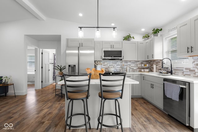 339 Honey Locust Pl, North Vernon, IN 47265 - kitchen featuring appliances with stainless steel finishes, decorative backsplash, gray cabinets, a kitchen bar, and light countertops