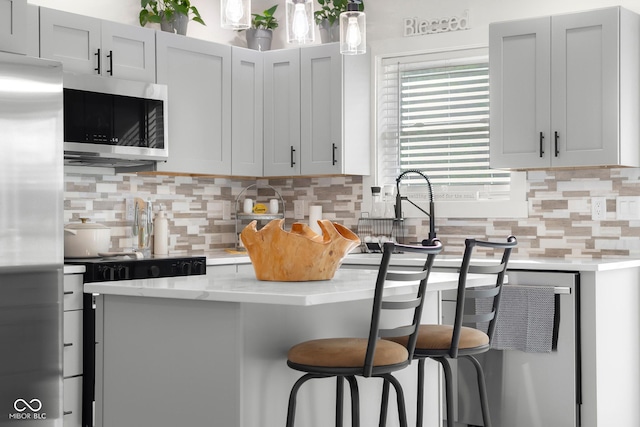 339 Honey Locust Pl, North Vernon, IN 47265 - kitchen featuring stainless steel appliances, backsplash, a breakfast bar, light stone countertops, and pendant lighting
