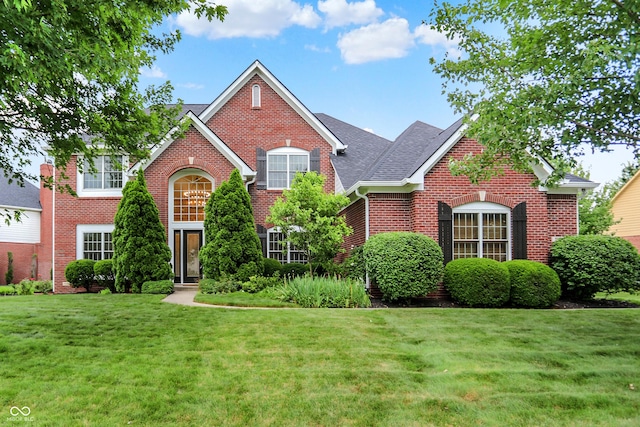 5761 Coopers Hawk Dr, Carmel, IN 46033 - traditional home featuring brick siding, a front yard, and roof with shingles