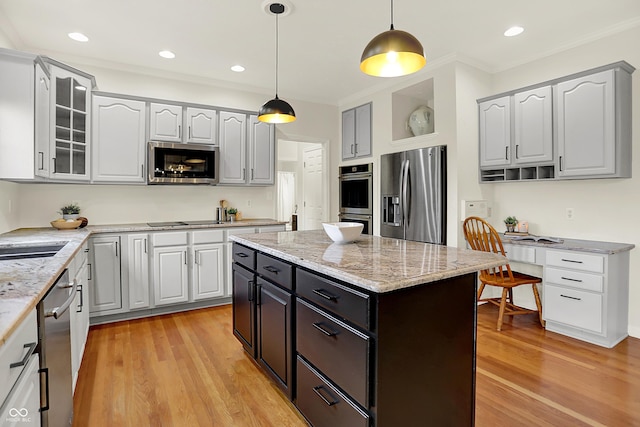 5761 Coopers Hawk Dr, Carmel, IN 46033 - kitchen with appliances with stainless steel finishes, glass insert cabinets, light wood finished floors, decorative light fixtures, and crown molding