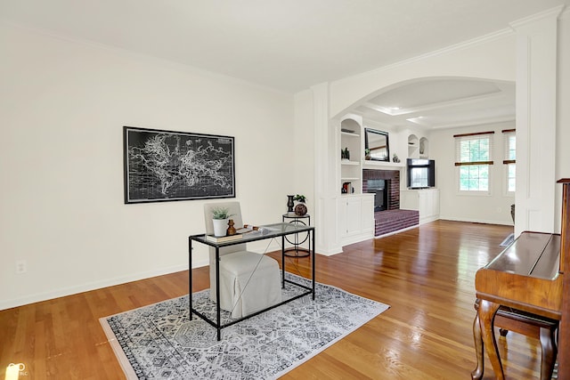 5761 Coopers Hawk Dr, Carmel, IN 46033 - office featuring arched walkways, a fireplace, ornamental molding, wood finished floors, and built in features