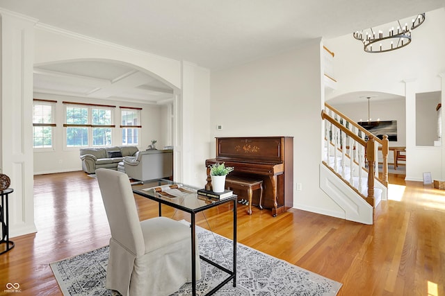 5761 Coopers Hawk Dr, Carmel, IN 46033 - dining space with arched walkways, a chandelier, stairs, wood finished floors, and coffered ceiling