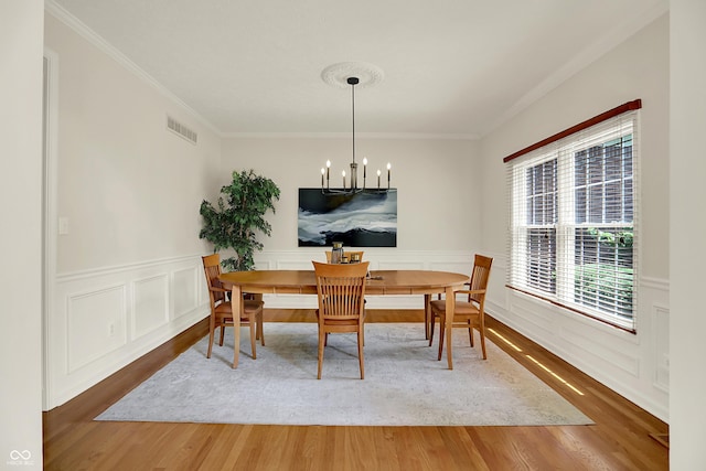 5761 Coopers Hawk Dr, Carmel, IN 46033 - dining area with wood finished floors, a chandelier, ornamental molding, and a wainscoted wall