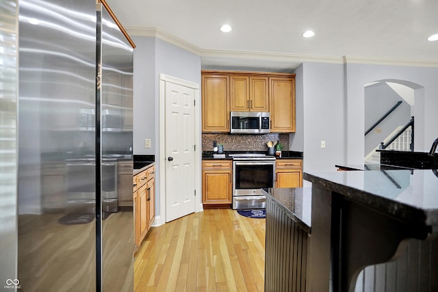2263 Glebe St, Carmel, IN 46032 - kitchen with stainless steel appliances, ornamental molding, light wood-style flooring, recessed lighting, and decorative backsplash
