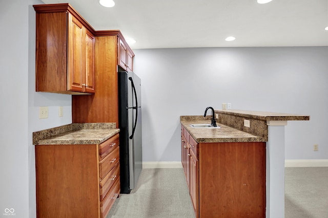 2263 Glebe St, Carmel, IN 46032 - kitchen featuring freestanding refrigerator, brown cabinetry, light carpet, a peninsula, and recessed lighting