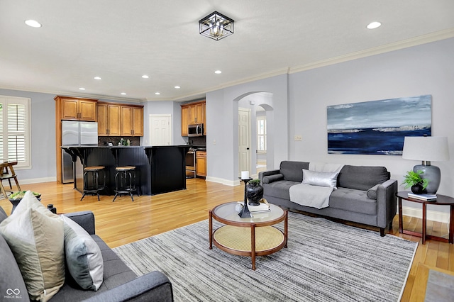 2263 Glebe St, Carmel, IN 46032 - living room featuring arched walkways, crown molding, light wood-style flooring, and recessed lighting
