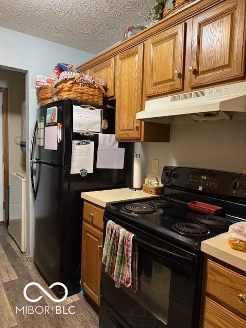 18 Hough St, Greenfield, IN 46140 - kitchen featuring black electric range, under cabinet range hood, brown cabinets, washer / clothes dryer, and a textured ceiling