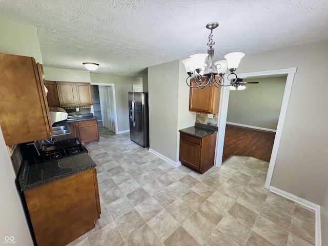 1345 S Biltmore Ave, Indianapolis, IN 46241 - kitchen with stainless steel fridge, stove, a chandelier, a textured ceiling, and pendant lighting