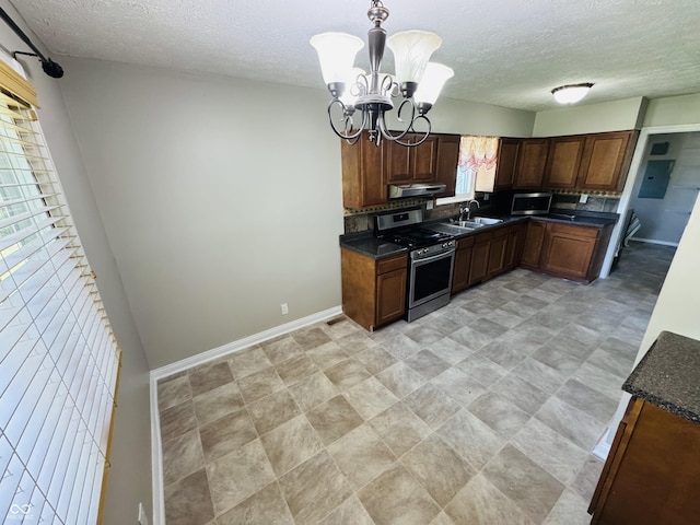 1345 S Biltmore Ave, Indianapolis, IN 46241 - kitchen with appliances with stainless steel finishes, a chandelier, under cabinet range hood, a textured ceiling, and decorative light fixtures