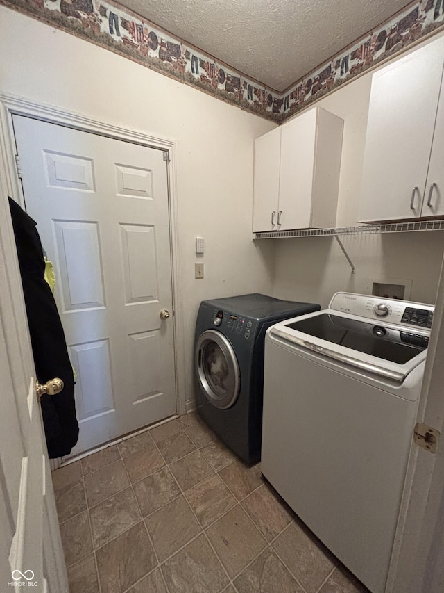 2929 Tuscarora Ln, Indianapolis, IN 46217 - laundry area with cabinet space, separate washer and dryer, and a textured ceiling