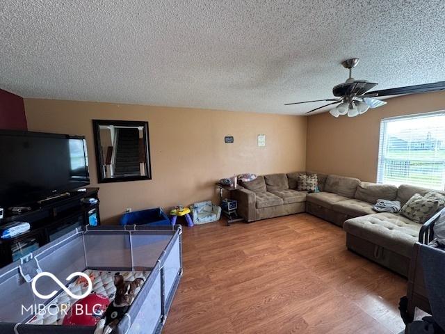 2230 Cedarmill Dr, Franklin, IN 46131 - living room featuring a textured ceiling, a ceiling fan, and wood finished floors