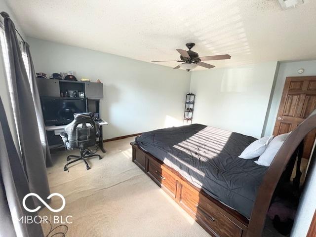 2230 Cedarmill Dr, Franklin, IN 46131 - bedroom with light colored carpet, ceiling fan, and a desk