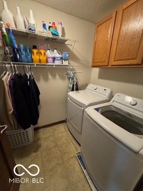 2230 Cedarmill Dr, Franklin, IN 46131 - laundry room featuring separate washer and dryer, a textured ceiling, and cabinet space