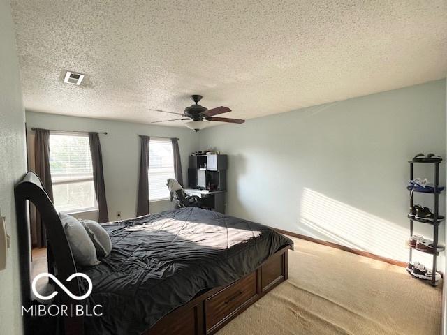 2230 Cedarmill Dr, Franklin, IN 46131 - bedroom featuring a textured ceiling, light colored carpet, and a ceiling fan