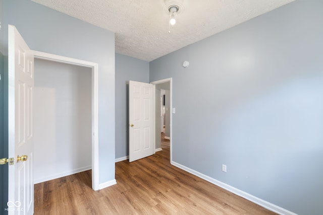 615 Udell St, Indianapolis, IN 46208 - unfurnished bedroom with wood finished floors and a textured ceiling