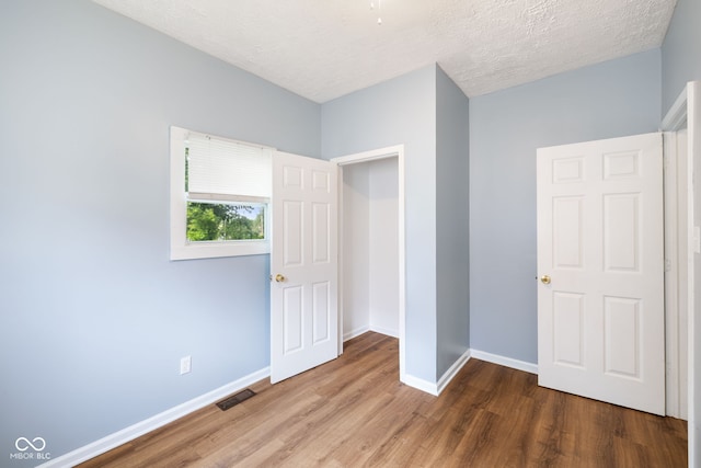 615 Udell St, Indianapolis, IN 46208 - unfurnished bedroom featuring wood finished floors and a textured ceiling