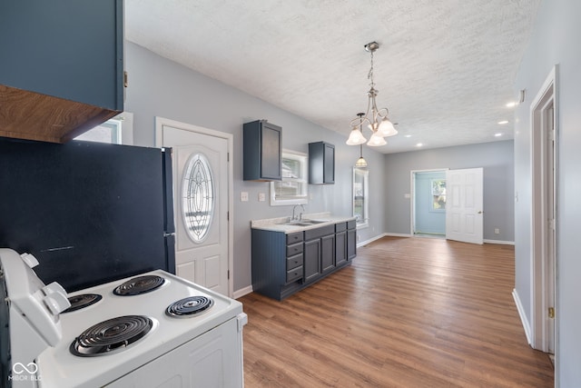 615 Udell St, Indianapolis, IN 46208 - kitchen with electric stove, freestanding refrigerator, a chandelier, light countertops, and light wood-style floors