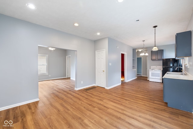 615 Udell St, Indianapolis, IN 46208 - kitchen with white electric range, light wood-style floors, light countertops, recessed lighting, and a chandelier